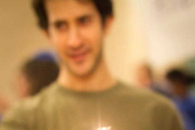 Preparing to illuminate the menorah, senior Zach Stauber holds the shamash, the test tube designated to light the others.