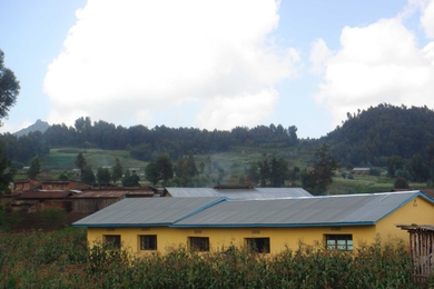 A clinic in the village of Bisate, Rwanda, the yellow building in foreground, was equipped with storage tanks to collect rainwater for use during the area's dry seasons. The corrugated metal roof was fitted with gutters to carry the water to several large collecting tanks, using a 'first-flush' diversion system to separate out the first, dirty water at the beginning of each rainfall.