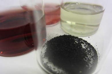 Researchers have combined gold nanoparticles (in light red) with copper nanoparticles (in light green) to form hybrid nanoparticles (dark red), which they turned into powder (foreground) to catalyze carbon dioxide reduction.