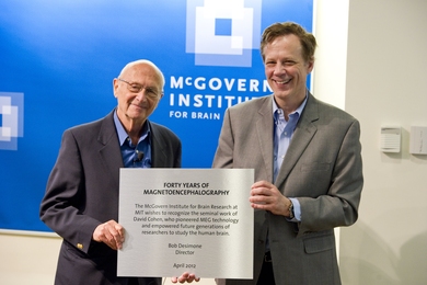 Robert Desimone, director of the McGovern Institute, presents David Cohen with a plaque commemorating the 40th anniversary of the invention of MEG.