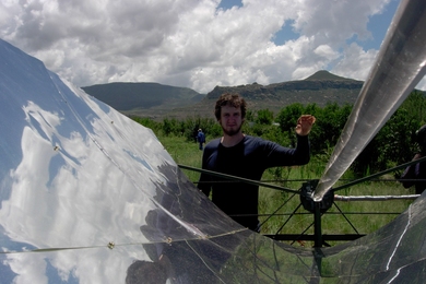 Matthew Orosz stands with a parabolic solar collector in Lesotho in January 2006. During this trip, funded by IDEAS awards and Public Service Center fellowships, Orosz and his team deployed their second field prototype.