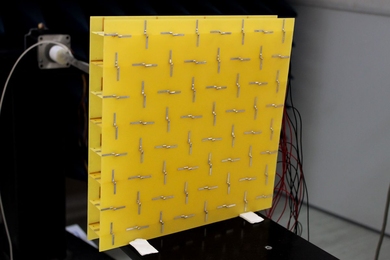 To prevent microwaves passing through it from reflecting backward, a new 'metamaterial' uses antennas of alternating orientations (top) that are connected by amplifier circuits (bottom).