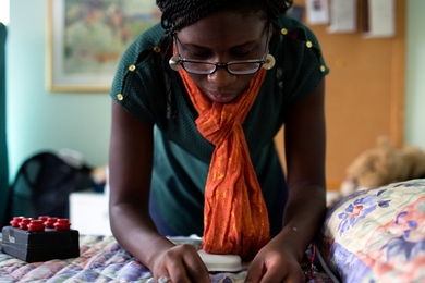 Joy Ekuta, a senior in the Department of Electrical Engineering and Computer Science, tests nurse call system equipment. Ekuta is helping to design a new nurse call system for a person with multiple sclerosis.