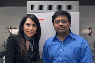 MIT postdoc Gisele Azimi, left, displays three of the 13 different ceramic disks made from oxides of the rare earth elements, with associate professor Kripa Varanasi. Behind them is the furnace used to convert the powdered oxides into solid ceramic form.