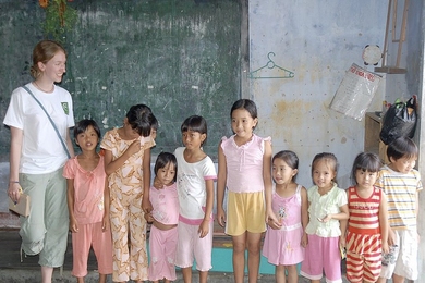 Laura Chirot poses with rural kindergarten children in central Vietnam.