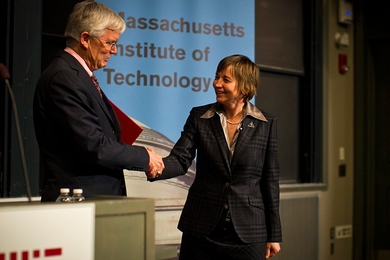 MIT faculty chair Robert Gibbons presents Maria Zuber with the Killian Award certificate.