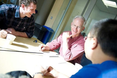 Three men in discussion at a table