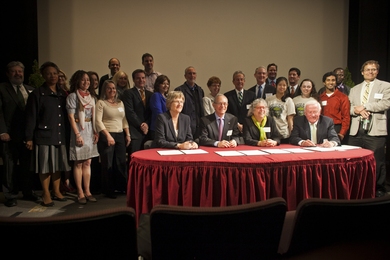Seated at the table, from left: Harvard President Drew Faust, MIT President L. Rafael Reif, Cambridge Mayor Henrietta Davis and Cambridge City Manager Bob Healy sign the "Community Compact for a Sustainable Future."