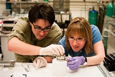 MIT graduate researchers Robert Mitchell and Betar Gallant connect a Li-air battery used to prepare the samples for in-situ Transmission Electron Microscope (TEM) characterization.
