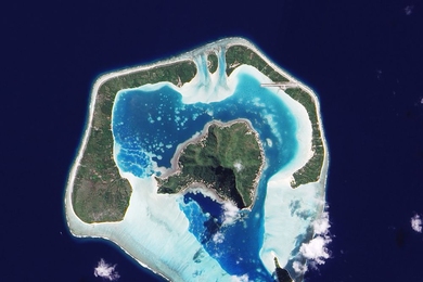 A satellite image of Maupiti, one of the Society Islands, which is on its way to becoming an atoll. Submerged reef appears in pale blue.
