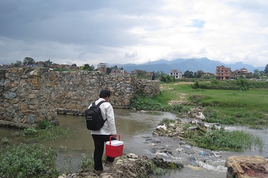 Shambhu Baral, Shawn Wen's field research partner, carries a PortaTherm prototype while walking to one of 19 peri-urban and rural health posts where they conducted product demos and interviews with health workers last summer.