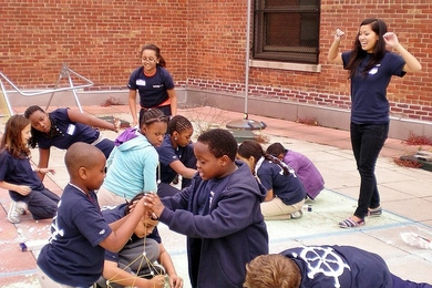 MITxplorers build skyscrapers with spaghetti and marshmallows under the encouragement of co-president and mentor Debbie Nguyen (right).