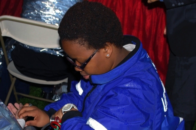 EMT Anita Wamakima, ’15, monitors the vital signs of a badly chilled patient in the medical tent at MIT’s 2013 Commencement.