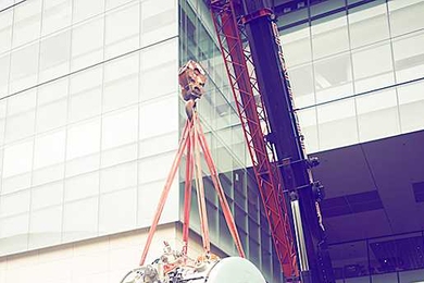 A crane hoists a 13-ton MRI scanner outside of the McGovern Institute for Brain Research at MIT.
