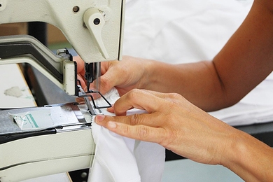 Photo of a hand manipulating cloth in a sewing machine