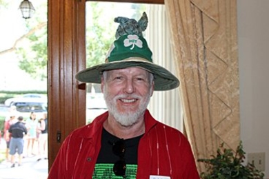 A person wears a green pointy hat and red button-up shirt