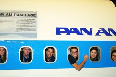 MIT LGO students playfully gaze from the windows of a airplane fuselage at Boeing.