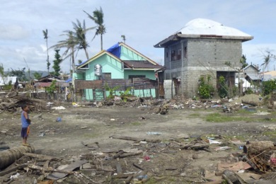 A child surveys damage outside of his home in San Jose, a neighborhood of Tacloban, Philippines, located on the ocean.  Everything close to shore was washed away by the November 2013 storm surge.