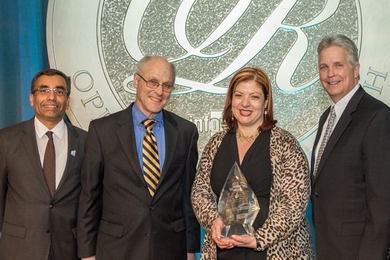MIT LGO’s Georgia Perakis holds the UPS George D. Smith Prize trophy, alongside LGO program director Don Rosenfield (to her right). With them are Ranganath Nuggehalli, chair of the 2014 UPS George D. Smith Prize Committee (far left), and Randy Stashick, global vice president of engineering for UPS (far right).