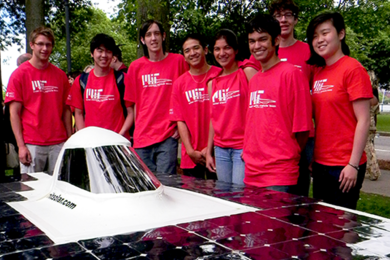 Students stand next to a solar car