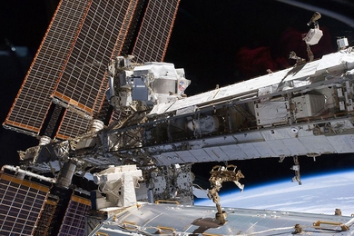 The starboard truss of the International Space Station while Space Shuttle Endeavour docked with the station. The newly installed Alpha Magnetic Spectrometer (AMS) is visible at center left.