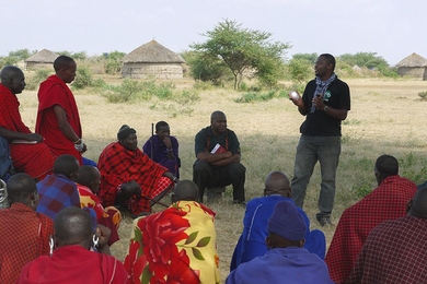 An employee of Global Cycle Solutions introduces a solar lamp to villagers in rural Tanzania.