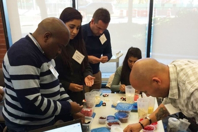 MIT Professional Education students from South Africa use Lego bricks in a manufacturing game to assemble small cars.