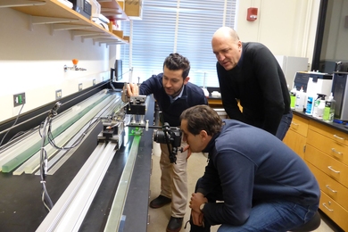 MIT Concrete Sustainability Hub principal investigators Franz-Josef Ulm and Roland Pellenq and research scientist Mehdi Akbarian run a pavement-vehicle interaction test that simulates a vehicle moving over pavement. The test determines excess fuel consumption induced by pavement material and structural properties. 