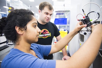 Ginkgo Bioworks staff members Ramya Prathuri (left) and Nate Tedford work at the mass spectrometer in the Ginkgo foundry.