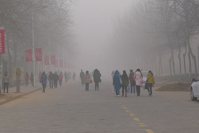 University students walk through dense air pollution at Anyang Normal University in Henan Province, China.