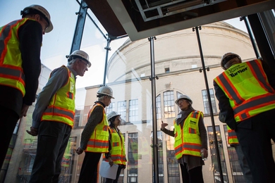 MIT Professor Krystyn Van Vliet (center) describes how MIT.nano clean rooms will provide a precisely controlled environment. MIT Corporation members Gregory Turner (second-from-left) and Madeleine Gaut (third-from-left) listen along with Anuradha Agarwal (fourth-from-left), a principal research scientist at the MIT Microphotonics Center. 