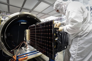 An engineer installs SensorSat, developed at Lincoln Laboratory, in the thermal-vacuum chamber used for testing the satellite's tolerance of conditions in space. 
