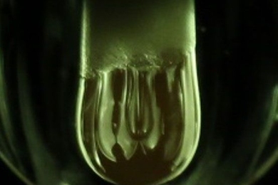 A molten hanging droplet, or pendant (at center), forms from an aluminum oxide rod under intense heat and light from xenon lamps. Using this process, MIT researchers have demonstrated a new electrochemical method to study thermodynamic processes in a molten oxide melt at temperatures above 2,000 degrees Celsius. 