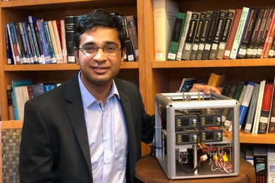 Ashok Ajoy PhD ’16, poses with a prototype hyperpolarizer device.