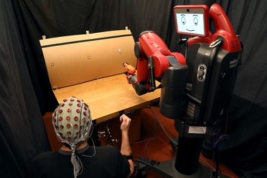 A system developed at MIT allows a human supervisor to correct a robot's mistakes using gestures and brainwaves.