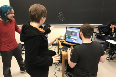 MIT undergraduate Mark Vrablic (standing, left) engages as the teaching assistant and mentor for a student group building a video game in a nine-day workshop that he helped design and publish on MIT’s OpenCourseWare along with Department of Materials Science and Engineering lecturer Kyle Keane and Andrew Ringler from the Interactive Materials Education Laboratory.
