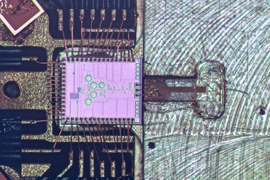 The clock transmitter chip (pink) wired to a circuit board package. Connected is a metal gas cell (right), in which a 231.061 GHz signal generated from the chip excites the rotation of carbonyl sulfide molecules. Because the peak rotation of the molecules is constant, it can be used as a reference point to keep accurate time.