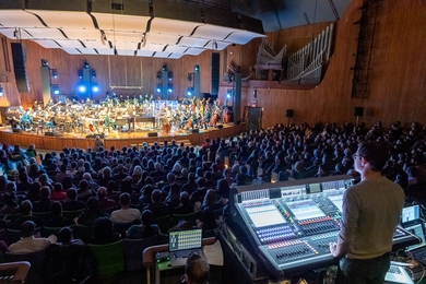 MIT student Ben Bloomberg stands behind the soundboard at a Jacob Collier concert, December 2018.