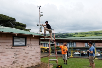 Postdoc Ben Crawford installs a volcanic air pollution sensor at an elementary school on the Big Island of Hawaii. 