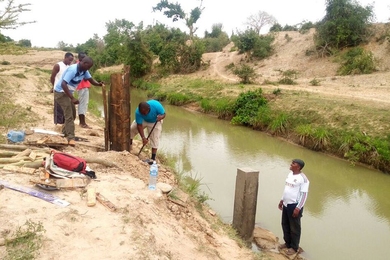 Kenya Water Resources Management Authority workers build a water quality monitoring station on the Mwache River.