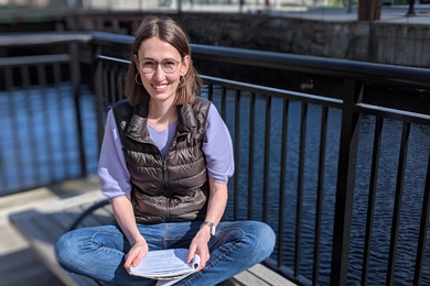 2018-19 J-WAFS Fellow Andrea Beck sits by the Charles River. 