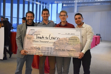 First Place 2019 $15K Creative Arts Competition team Teach to Learn, a global music mentorship program, receives their prize from MIT competition organizer Sam Magee (left). 