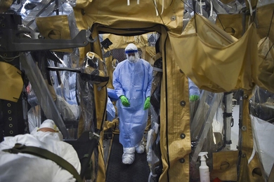 An airman performs the final set of checks during transportation isolation system (TIS) training while practicing patient care in a containment unit. Engineered and implemented after the 2014 Ebola virus outbreak, the TIS is an enclosure the U.S. Defense Department can use to safely transport patients with highly contagious diseases.