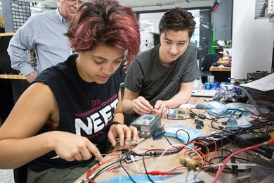 PJ Hernandez (left) and Jackson Gray (right) build circuits in the lab of Professor James Kirtley (background) as part of their summer energy UROP. One of the problems they worked on together was how to develop an improved cell voltage balancer, a device used to extend the life of batteries by working to ensure that cells remain evenly charged as the battery cycles.