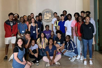 NEXUS program participants pose with the MIT seal in Lobby 7. The NEXUS program provides college-bound students with the tools needed to thrive on campus, focusing on academic and career development, and offers opportunities to build confidence and self-sufficiency away from home. 