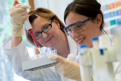 Photo of two female scientists in a lab experimenting with test tubes