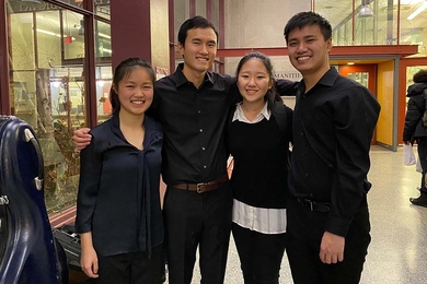 Photo of Jiaxing Liu, Alex Wang, Jeana Choi, and Jeff Chow standing with their arms around one another and smiling