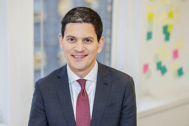 Portrait photo of David Miliband, smiling and wearing a suit and tie