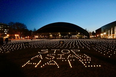 Kresge Oval lit with 3,797 battery-operated candles, formed in rows covering the field and shaped into the words "STOP ASIAN HATE"