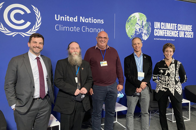 Five people standing in front of the UN Climate Change Conference banner